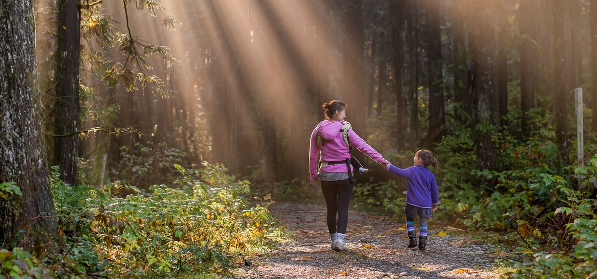 Eine Mutter geht mit ihrem Kind durch den Wald